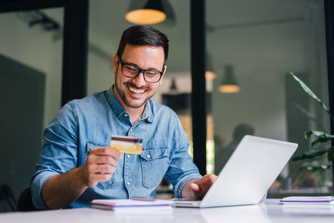 Man met creditcard laptop bril