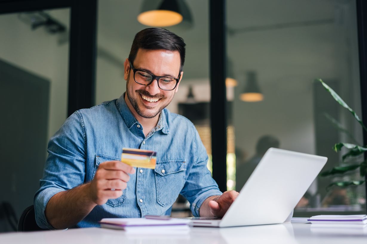 Man met creditcard laptop bril