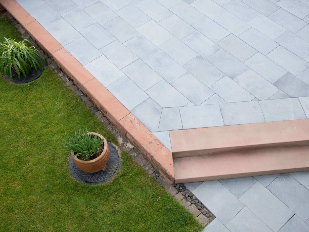 Kalkstenen terras met gras en planten
