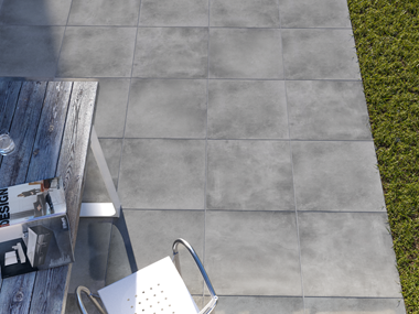 Zicht op terras met Ombra betonlook platen, graskanten en buitenmeubilair