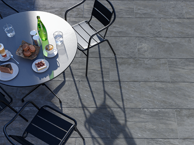 Zicht op terras met Monro Dark kwartsietlook platen en buitenmeubilair