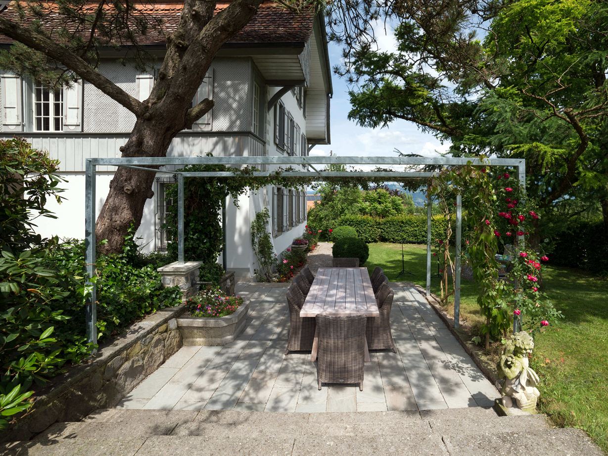 Terras met natuurstenen platen van grijze zandsteen in een natuurlijke tuin