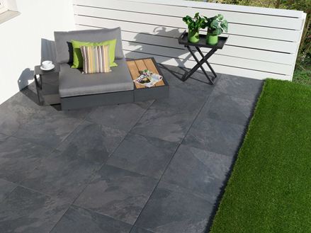 Terras met zwarte alpenplaten en loungebank