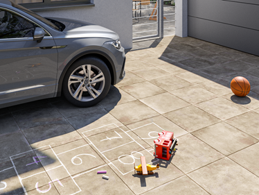 Oprit met Roma 3cm betonlook platen met auto en speelgoed