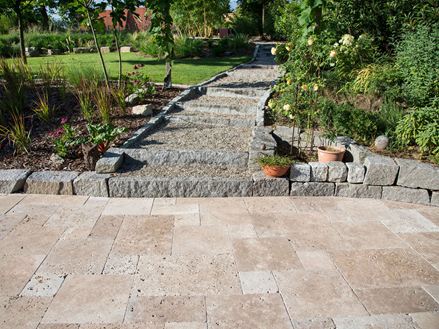 Terras met Noce travertin op de voorgrond, granieten rand, tuin op de achtergrond
