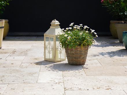 Rustieke travertin platen met lantaarn en bloemen