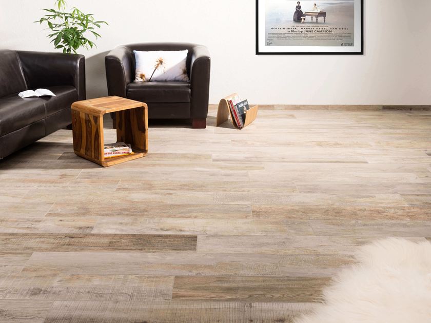Zithoek met kleine houten bijzettafel en houtlook porcellanato tegels op de vloer