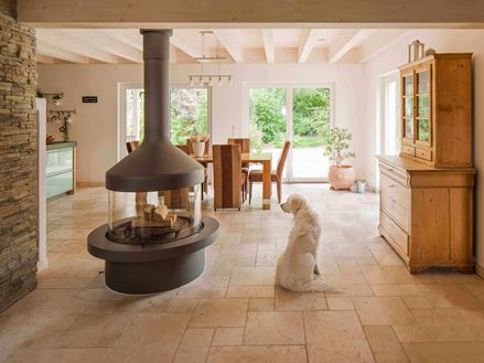 Lichte tegels in de woonkamer met open haard en hond