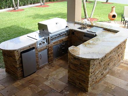 Buitenkeuken met natuursteen en tuin op de achtergrond