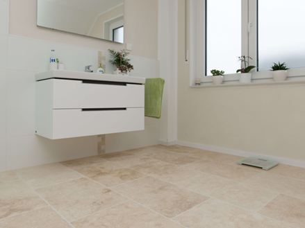 Lichte travertin tegel in moderne badkamer met wit meubilair