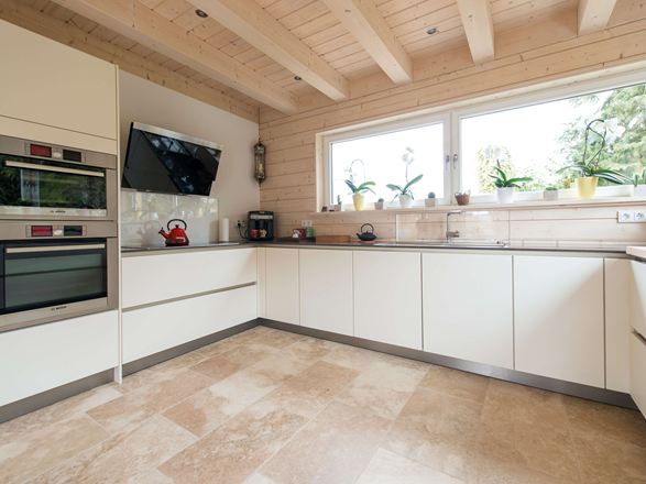 Keuken met witte meubels en beige Rustieke travertin tegels als vloerbedekking