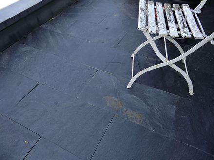 Klantenfoto: Balkon met zwarte rustieke platen en een vintage stoel