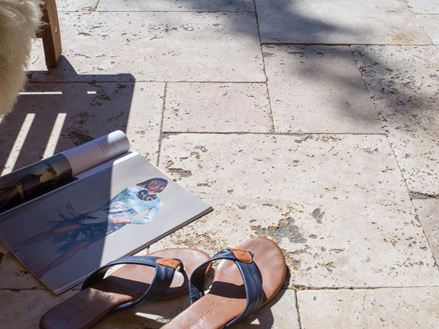 Tijdschrift en schoenen op travertijn terras Rustiek